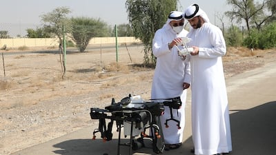 Mohammad and Abdulla Al Moosa with the drone pollination device. Wajod Alkhamis / The National