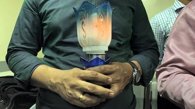 A relative holds a candle on June 8. Pawan Singh / The National