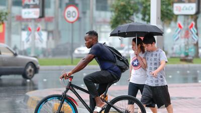 Abu Dhabi residents cross the intersection of Hazza Bin Zayed The First St. and Sultan Bin Zayed The First St. during a rain shower. Victor Besa / The National