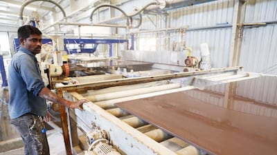 A worker checks one of the larger ceramic tiles. RAK Ceramics ships these to more than 160 countries around the world. Pawan Singh / The National