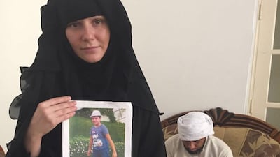 Tatiana Kruzina holds a picture of her son Athan. Behind is father Majid Janjua. Haneen Dajani / The National