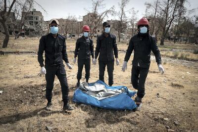 A team of firefighters in central Raqqa carry a body bag out of the city. David Pratt for The National