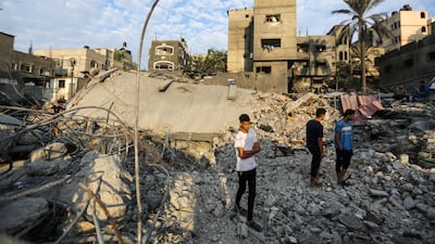 People stand in the rubble of buildings destroyed during Israeli air raids in Khan Younis, Gaza, on Friday. Getty