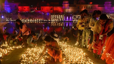 People lighting earthen lamps on the banks of the River Sarayu on the eve of Diwali. AFP