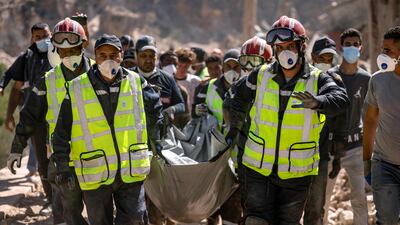 Rescue workers carry a body from the rubble of a house in Imi N'Tala village near Amizmiz. AFP