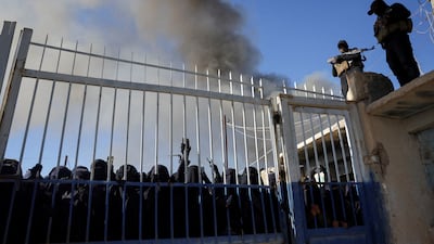 Members of the Syrian security forces stand guard over a group of female detainees. Reuters