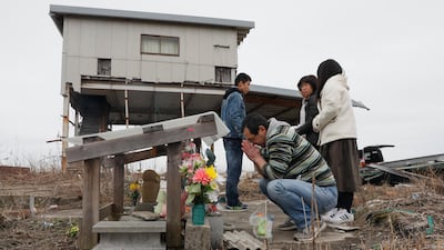 Takaaki Shiga offers a prayer for his late mother Saiko, who was killed by tsunami at age of 63, at remains of his house in Nakano district, Futaba, Fukushima Prefecture, Japan, on March 11, 2018. Kimimasa Mayama / EPA