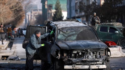An Afghan security member inspects a damaged vehicle after a bomb blast in Kabul, Afghanistan, Sunday, December 13, 2020. AP