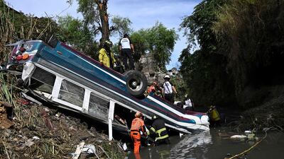 Firefighters work at the scene of an accident in which a bus fell down a ravine in Guatemala City. AFP
