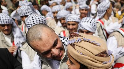 A freed prisoner talks to his son after landing on an ICRC-chartered plane after it arrived at Sanaa Airport. Reuters