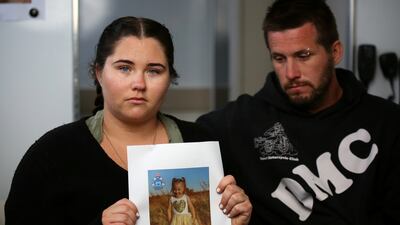 Cleo’s mother Ellie Smith, standing with her partner Jake Gliddon, holds up a photo of her missing daughter. Reuters