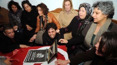 Basma Khalfaoui Belaid (second from right), the widow of slain Tunisian opposition leader Chokri Belaid, cries with relatives around her husband’s coffin in Tunis.