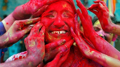 A woman reacts as devotees apply coloured powder on her face during Holi celebrations outside a temple near Kolkata, India. Reuters
