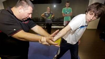 Stephen Drake, a martial-arts instructor, shows Nahum Strickland how to evade an attacker’s grip as Haley and Joe Jones take notes in Dubai.