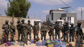 Israeli soldiers stand in front of a Palestinian house besieged by settlers in Qusra, with supplies left for the residents by activists. AFP