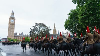 Troops of the Household Cavalry make their way through Parliament Square. PA