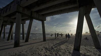 Surfers watch from the beach as waves generated by Tropical Storm Karen roll to the shore next to the Pensacola Beach Pier at Pensacola Beach, Florida. Reuters/Steve Nesius