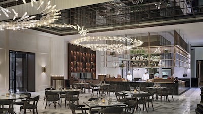 The interiors of Brasserie Boulud feature decor inspired by art deco design, with a mirrored ceiling, dramatic chandeliers and neutral tones. Photo: Brasserie Boulud