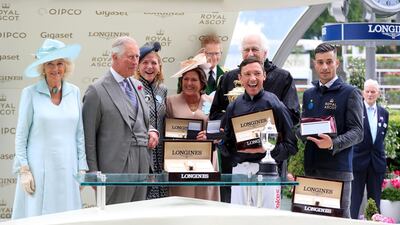 The Duchess of Cornwall, left, and the Prince Charles, second left, present jockey Frankie Dettori and winning connections with the trophy after winning the Prince of Wales's Stakes with Crystal Ocean. Press Association