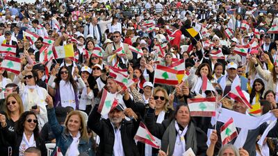 People wave Lebanese flags at a mass led by Pope Leo at the Beirut waterfront. EPA