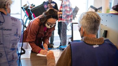 Election official Scott Hagara, right, checks in a voter at the board of elections headquarters during early voting in Painesville, Ohio. AFP