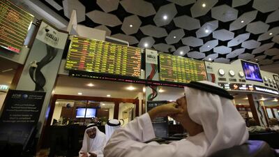 Investors follow the shares on a monitor screen at the Dubai Financial Market. Ali Haider / EPA