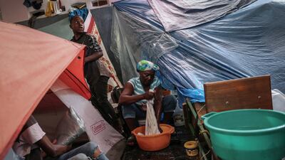 Mirriam Auge, 45, washes clothes at Darius Denis school