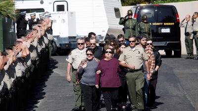 Family members are saluted by law enforcement officers after the hearse carrying the body of Sergeant Ron Helus arrived at the medical examiner's office in Ventura. EPA
