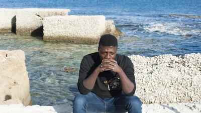 In this photo taken on Friday, November. 11, 2016, Marc Samie sits by the sea in Pachino, Sicily, waiting for news of his pregnant wife Louise, who he last saw standing on a beach in Libya. tears rolling down her face as traffickers forced him into a rubber dinghy at gunpoint. Salvatore Cavalli / AP