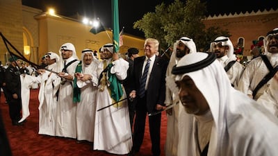 President Donald Trump holds a sword and sways with the traditional dancers. Evan Vucci / AP Photo