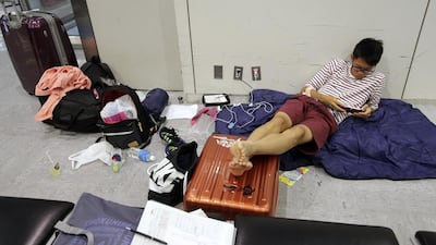 A passenger plays a game at Narita international airport. Shizuo Kambayashi / AP Photo