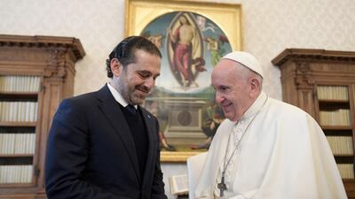 Pope Francis and Lebanon's prime minister-designate Saad Hariri exchange gifts during a private audience in The Vatican. Vatican Media / Reuters