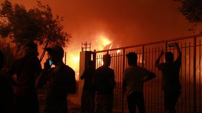 Refuees stand outside the Moria camp on the island of Lesbos during a major fire there. AFP
