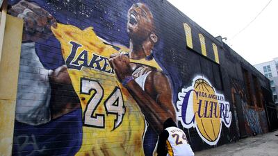 A fan pays respects at a mural depicting Kobe Bryant in a downtown Los Angeles alley after word of the Lakers star's death in a helicopter crash, in downtown Los Angeles Sunday, January 26, 2020. AP Photo/Matt Hartman