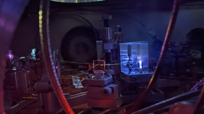 A powerful laser shines into a jet of gas, creating a bright plasma and generating ultraviolet light. The light leaves a visible white line as it interacts with leftover gas in the vacuum chamber. This process helps scientists precisely measure the energy needed to excite the thorium-229 nucleus, which is the core of a future nuclear clock. Photo: Chuankun Zhang/JILA