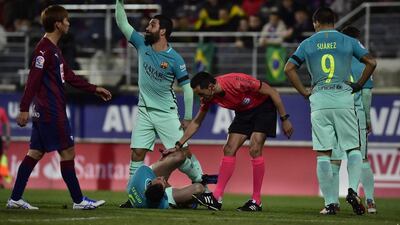 Barcelona midfielder Arda Turan calls for assistance as Sergio Busquets lies on the pitch injured. Alvaro Barrientos / AP Photo