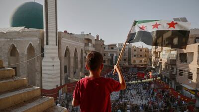Syrians in Zamalka mark the anniversary of a chemical weapons attack carried out by Bashar Al Assad's forces in 2013. AP