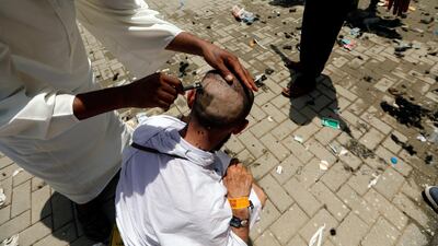 A Muslim pilgrim has his head shaved after casting seven stones at a pillar that symbolises Satan which is part of the annual haj pilgrimage rite in Mena. Reuters