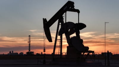 A pump jack and drilling rig south of Midland, Texas. Reuters