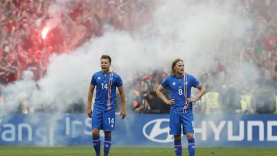 Iceland’s Kari Arnason and Iceland’s Birkir Bjarnason react as Hungary fans toss flares after their first goal in their Euro 2016 Group F match in Marseille. Yves Herman / Reuters