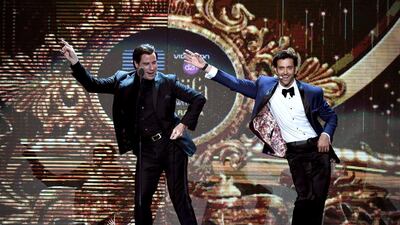 Hollywood actor John Travolta, left, shows Bollywood actor Hrithik Roshan a dance step on stage. Jewel Samad / AFP