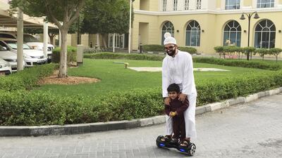 A man and his son ride a hoverboard outside the Market Shopping Centre in Green community in Dubai. Sarah Dea / The National