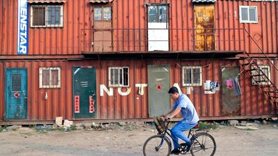 A cyclist passes container shelters in the urban-rural integration area of Qingdao. Wu Hong / EPA