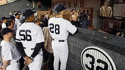 New York Yankees manager Joe Girardi, No 28, admires the monument to George Steinbrenner in Monument Park.