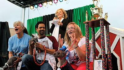 Bev Nicholson, of the UK, hears the announcement of Mugly's victory alongside Dane Andrew and dog Rascal, middle, and Kathleen Francis with Princess Abby. Beth Schlanker / AP Photo/ The Press Democrat