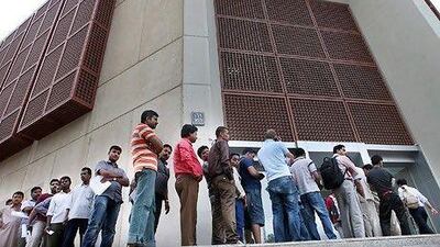 A long line of people waiting to pick up their Emirates ID cards wraps around the main post office in Abu Dhabi.