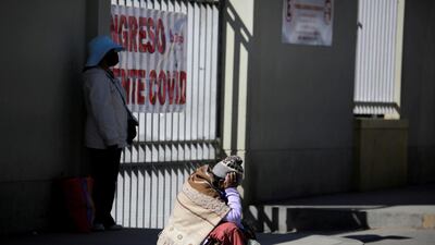 A woman who is suspected of having Covid-19 sits outside El Norte Hospital, La Paz, Bolivia. Reuters