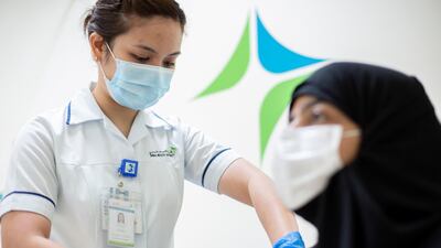 A woman receives the first dose of the Pfizer-BioNTech Covid-19 vaccine in Dubai. EPA