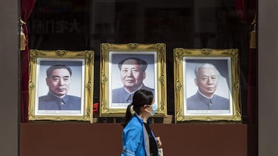 A pedestrian passes portraits of former Chinese leaders Zhou Enlai, left, Mao Zedong, centre, and Liu Shaoqi in Beijing, China. Bloomberg