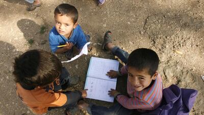 Boys play with a school book at a UNHCR’s camp for Syrian refugees in south Lebanon. Mahmoud Zayyat / AFP